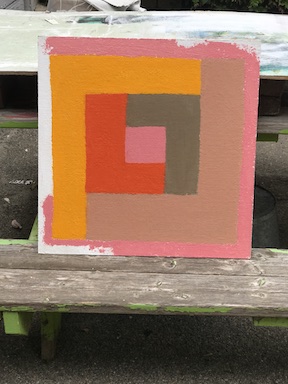A work--in-progress photograph of an acrylic painting placed outside on an old picnic bench